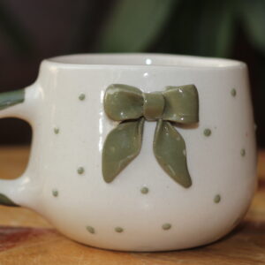 Cute white ceramic coffee mug with a 3D green bow detail