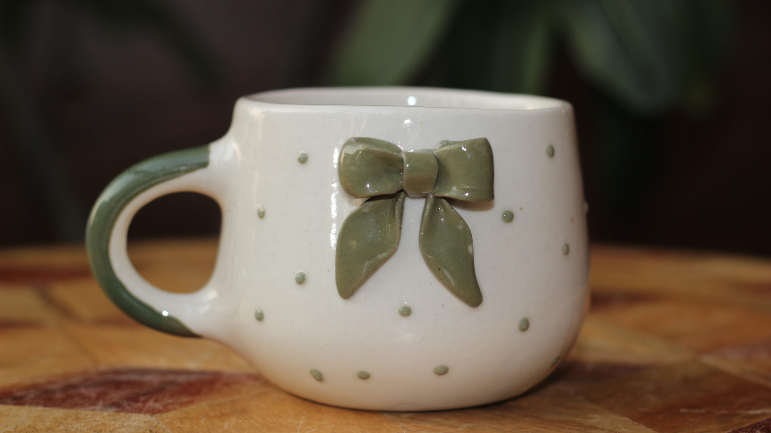 Cute white ceramic coffee mug with a 3D green bow detail
